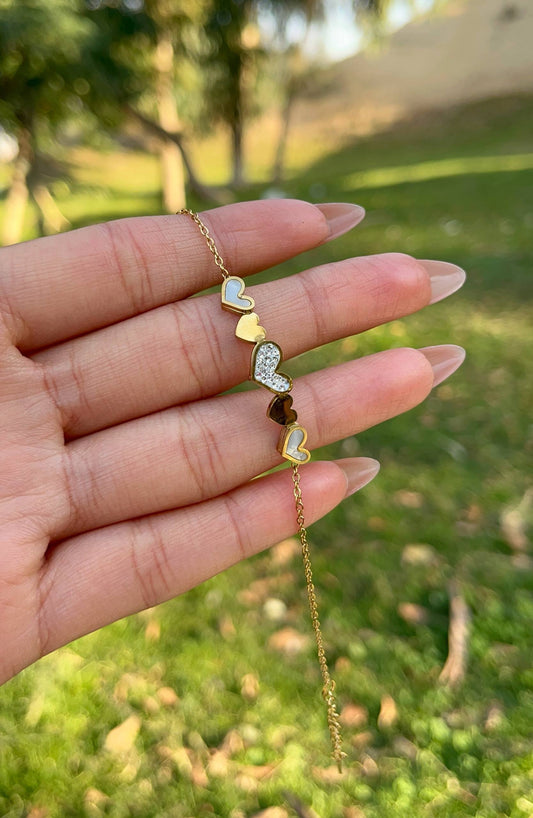 إسورة باللون الذهبي مزينة بخمس قلوب بتصميم متنوع من الزركون والصدف والمينا