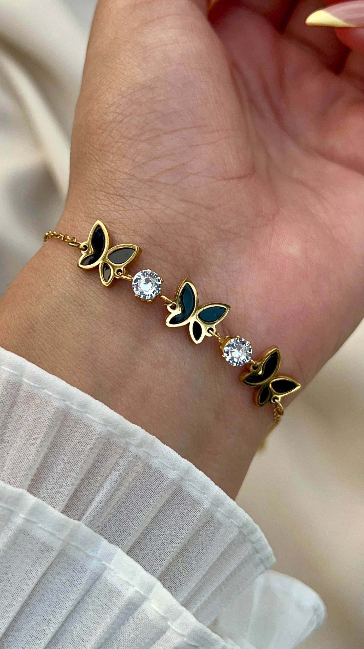 إسورة فراشة ستانلس بيور ذهبي مع تفاصيل سوداء وحبيبات كريستال لامعة