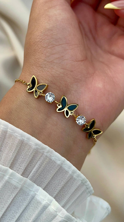 إسورة فراشة ستانلس بيور ذهبي مع تفاصيل سوداء وحبيبات كريستال لامعة