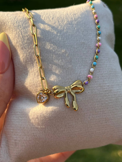 إسورة مطلية بالذهب بتصميم فيونكة مزينة بقلادة قلب وخرز ملون