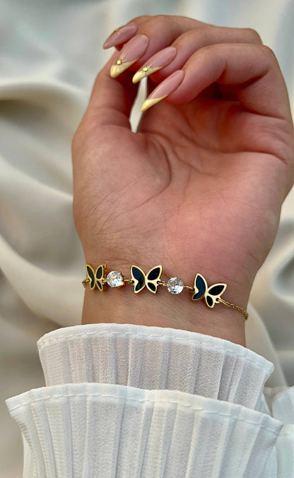 إسورة فراشة ستانلس بيور ذهبي مع تفاصيل سوداء وحبيبات كريستال لامعة