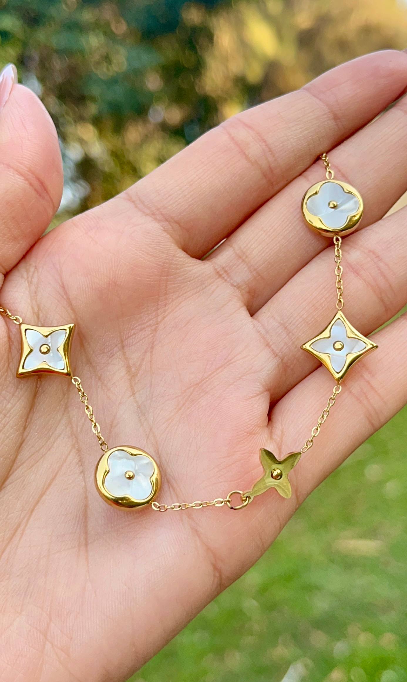 إسورة مطلية بالذهب من الستانلس ستيل مزينة بزهور بيضاء