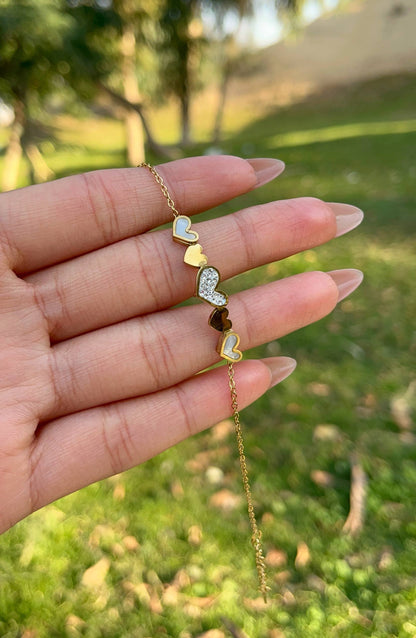 إسورة باللون الذهبي مزينة بخمس قلوب بتصميم متنوع من الزركون والصدف والمينا