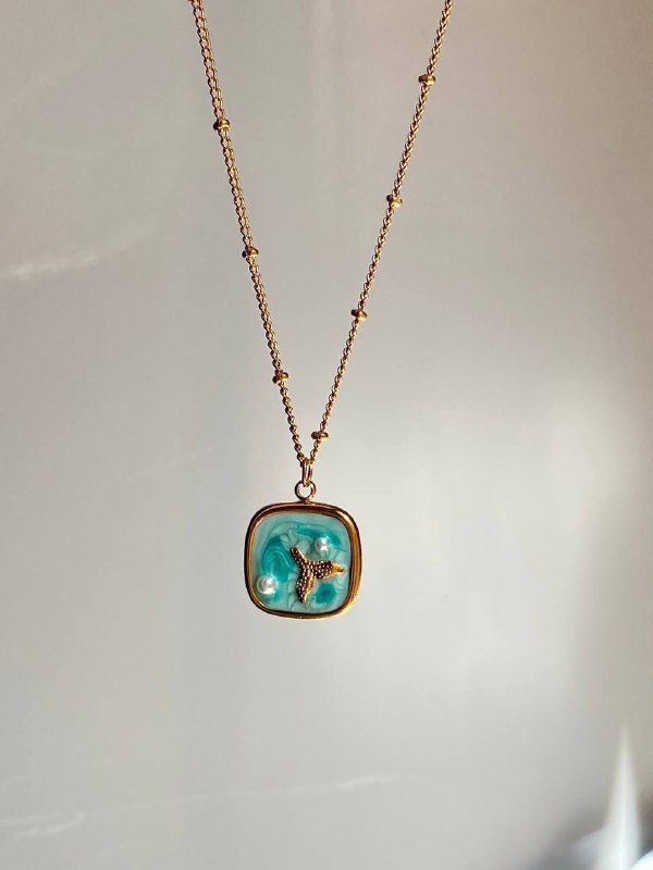 عقد بتعليقة صدفة باللون الذهبي مزينة بمينا زرقاء ولآلئ تقليدية