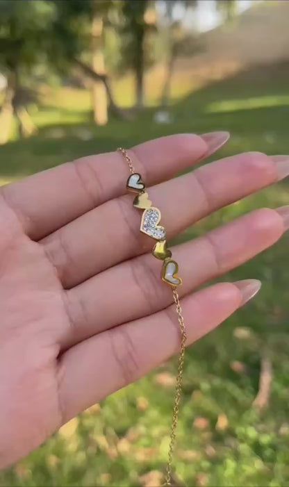 إسورة باللون الذهبي مزينة بخمس قلوب بتصميم متنوع من الزركون والصدف والمينا